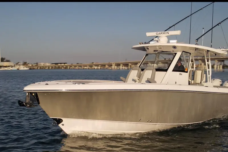 Slide: The Image of 2024 Everglades 395 Center Console boat cruising on calm waters. - 2