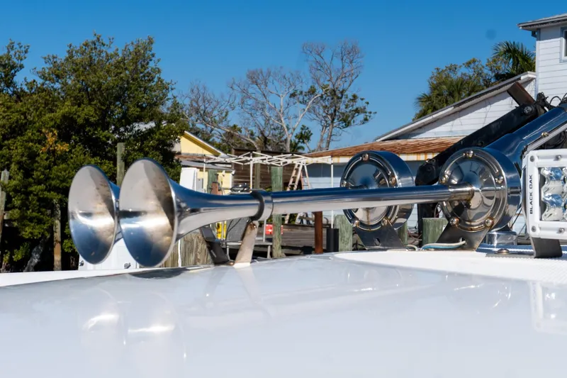 Slide: The Image of 2024 Everglades 395 Center Console boat horn detail with clear blue sky background. - 26