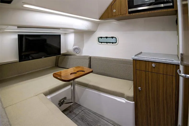 Slide: The Image of Manufacturer Provided Image: 2024 Everglades 395 Center Console cabin with seating, TV, and wooden table. - 52