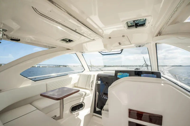 Slide: The Image of 2024 Pursuit OS 325 Offshore interior with modern helm and seating, overlooking the ocean. - 15