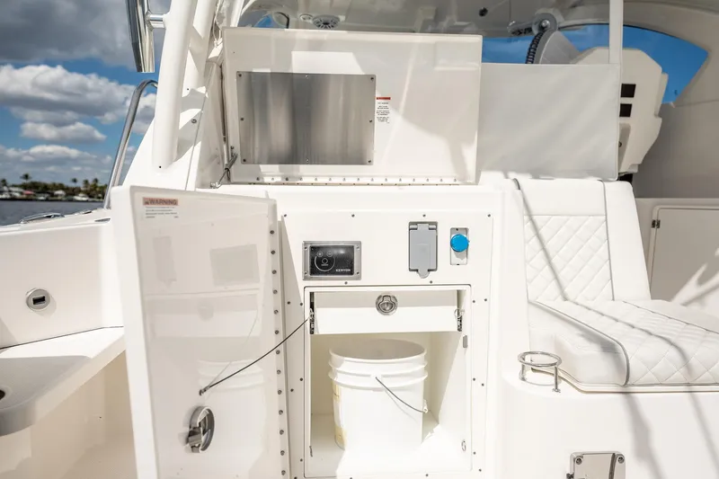 Slide: The Image of 2024 Pursuit OS 325 Offshore boat interior with open storage compartment and seating. - 17