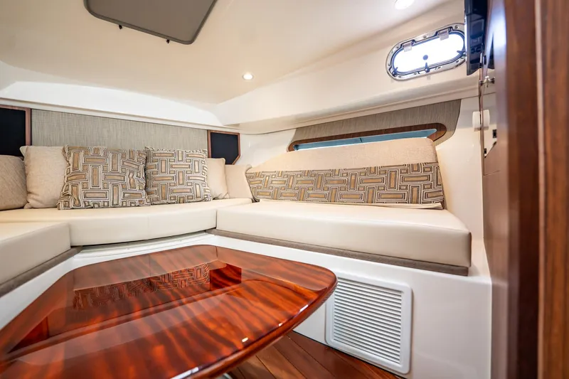 Slide: The Image of Luxurious interior of 2024 Pursuit OS 325 Offshore boat with elegant seating and wooden table. - 23