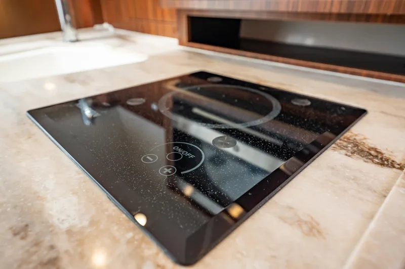 Slide: The Image of Modern stovetop on 2024 Pursuit OS 325 Offshore yacht, featuring sleek design and touch controls. - 25
