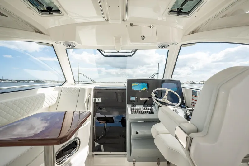 Slide: The Image of 2024 Pursuit OS 325 Offshore boat interior with modern helm and luxurious seating. - 5