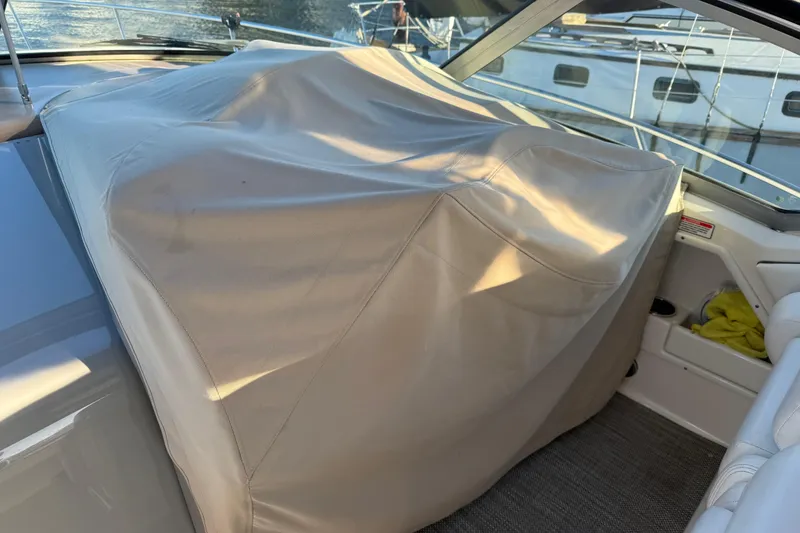 Slide: The Image of Covered helm station on a 2006 Sea Ray Sundancer 320 boat, docked near water. - 11