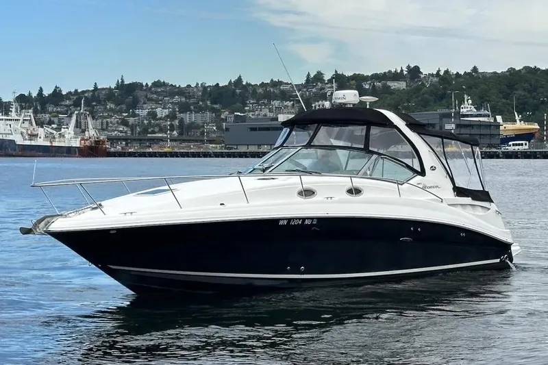 Slide: The Image of 2006 Sea Ray Sundancer 320 yacht on water, with cityscape background. - 2