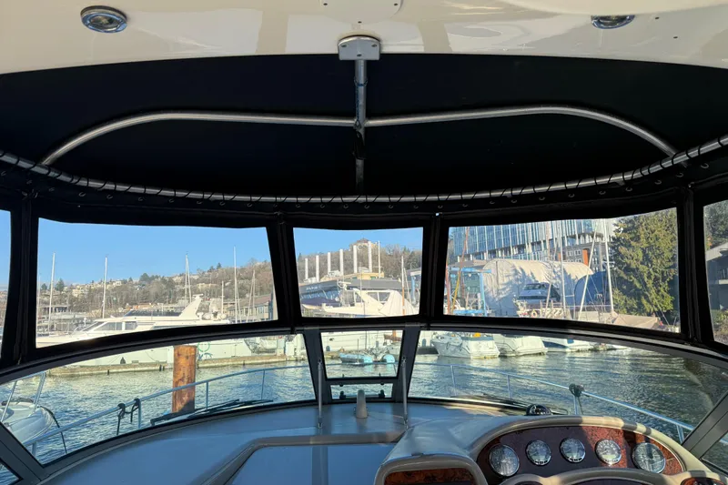 Slide: The Image of Interior view of 2006 Sea Ray Sundancer 320 yacht at marina, showcasing dashboard and waterfront. - 22