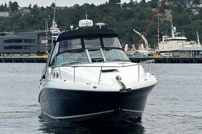 Slide: The Image of 2006 Sea Ray Sundancer 320 boat on water, with marina and trees in the background. - 3