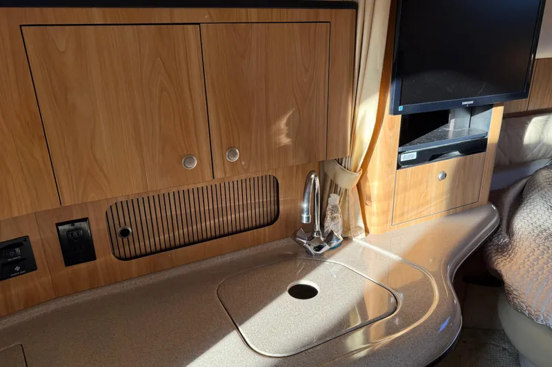 Slide: The Image of 2006 Sea Ray Sundancer 320 interior with wood cabinetry, sink, and TV. - 33