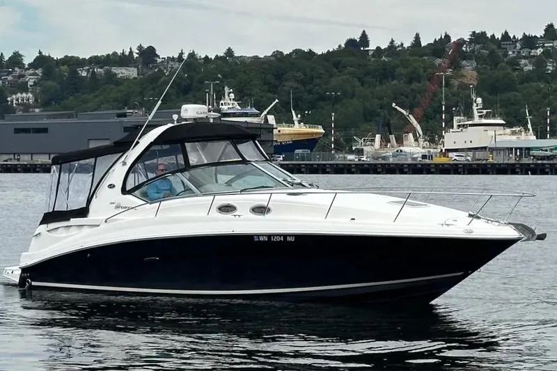 Slide: The Image of 2006 Sea Ray Sundancer 320 yacht cruising on a calm waterway with a scenic backdrop. - 4