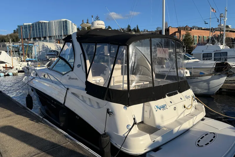 Slide: The Image of 2006 Sea Ray Sundancer 320 docked at marina, featuring sleek design and covered cockpit. - 53