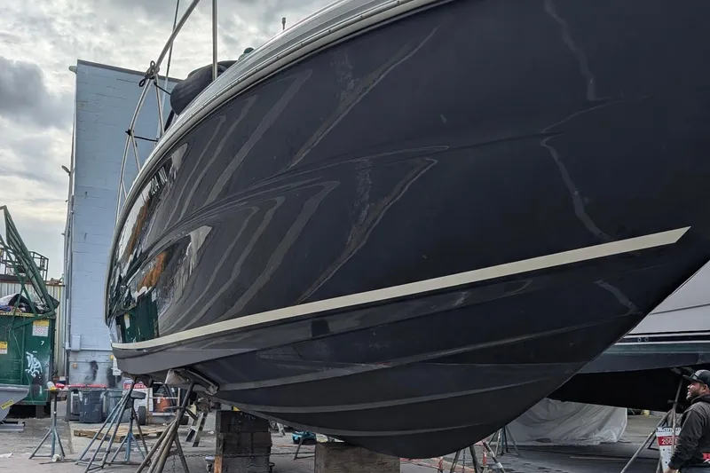 Slide: The Image of 2006 Sea Ray Sundancer 320 boat on dry dock, side view, with dark hull. - 59