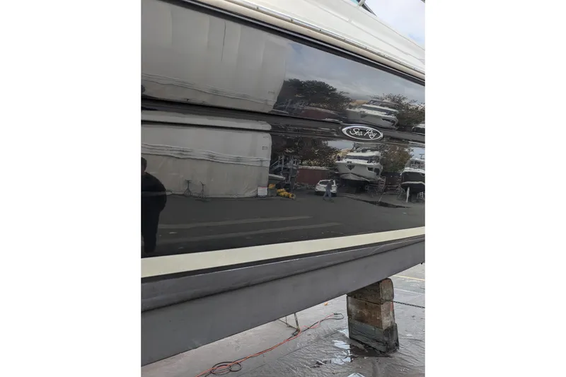 Slide: The Image of 2006 Sea Ray Sundancer 320 boat hull with logo, docked in a marina. - 60