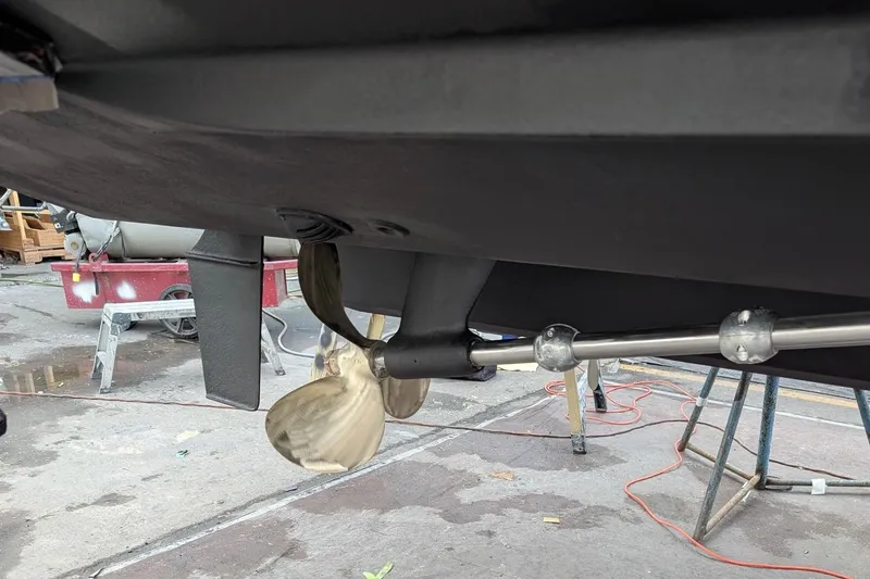 Slide: The Image of 2006 Sea Ray Sundancer 320 propeller and rudder detail in a boatyard setting. - 63