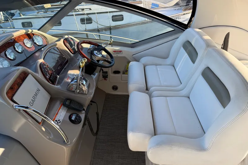 Slide: The Image of 2006 Sea Ray Sundancer 320 cockpit with white seating and navigation equipment. - 9