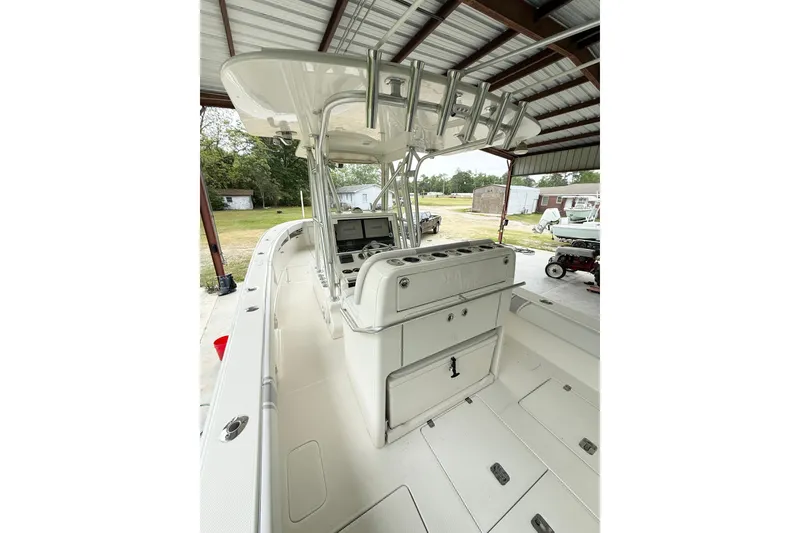 Slide: The Image of 2019 SeaVee 320B boat interior with helm station and rod holders in a covered area. - 13