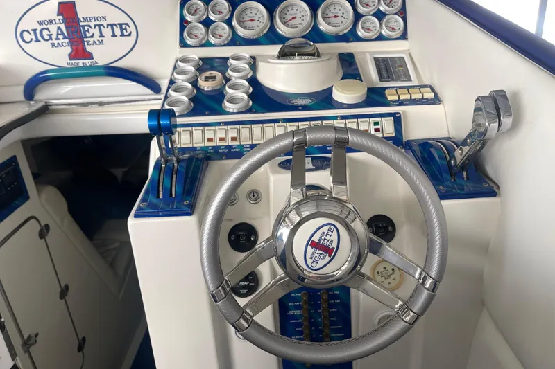 Slide: The Image of 1998 Cigarette 38' Top Gun boat dashboard with steering wheel and control panel. - 25
