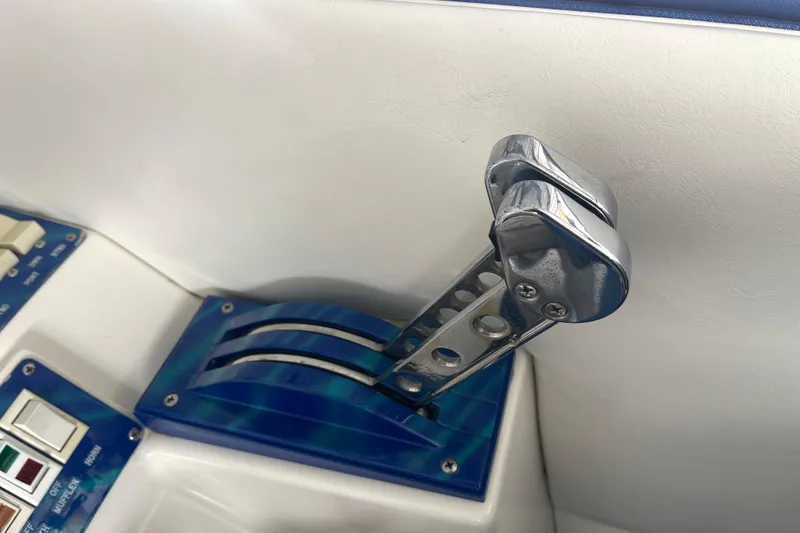 Slide: The Image of Throttle controls of a 1998 Cigarette 38' Top Gun boat, featuring chrome levers and blue accents. - 29
