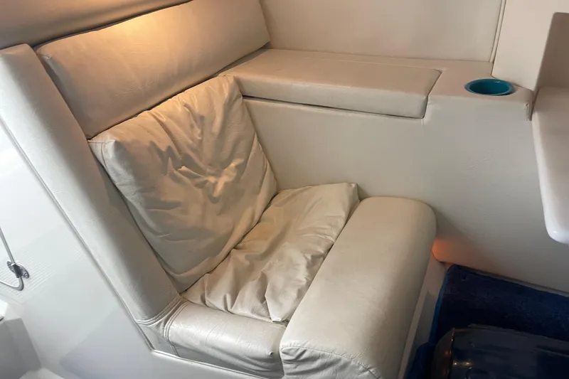 Slide: The Image of 1998 Cigarette 38' Top Gun boat interior with cushioned seating and cup holder. - 38