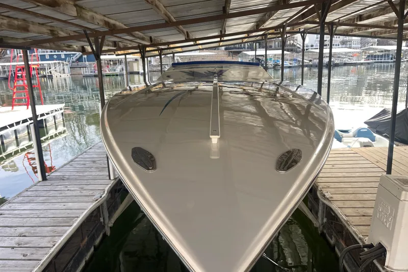 Slide: The Image of 1998 Cigarette 38' Top Gun boat docked under a covered marina. - 4