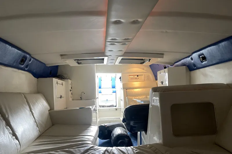 Slide: The Image of Interior of a 1998 Cigarette 38' Top Gun boat with white seating and blue accents. - 41