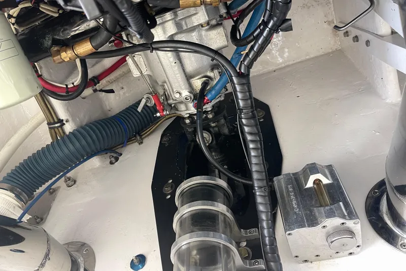 Slide: The Image of Engine compartment of a 1998 Cigarette 38' Top Gun boat, showcasing mechanical components and wiring. - 48