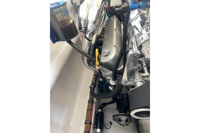 Slide: The Image of Engine compartment of a 1998 Cigarette 38' Top Gun boat, showcasing detailed components. - 54