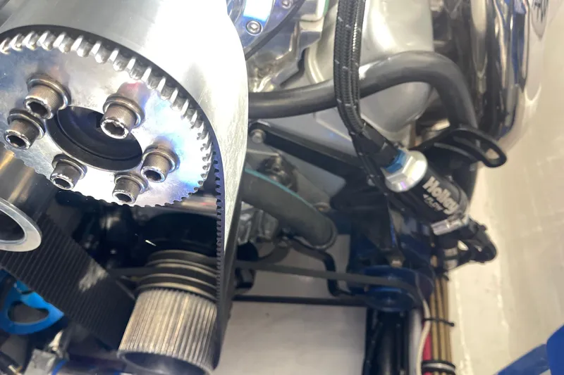 Slide: The Image of Engine components of a 1998 Cigarette 38' Top Gun boat, featuring belts and pulleys. - 55