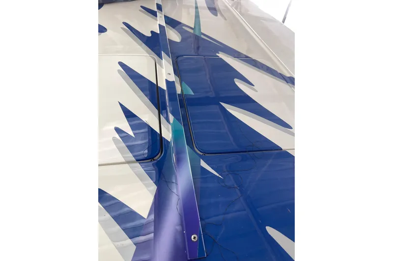 Slide: The Image of 1998 Cigarette 38' Top Gun boat with blue and white abstract design. - 56
