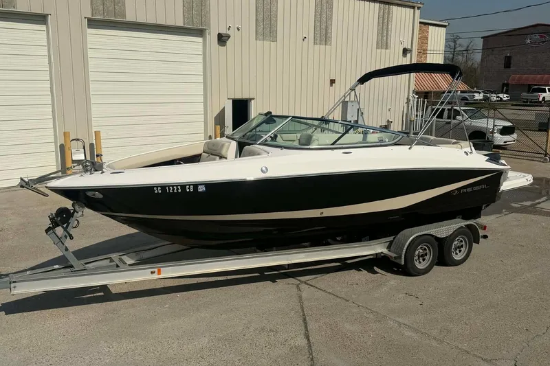 Slide: The Image of 2009 Regal 2500 Bowrider boat on trailer, parked outside industrial building. - 12