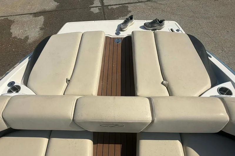 Slide: The Image of 2009 Regal 2500 Bowrider boat with beige seating and wooden deck, shoes on top. - 9