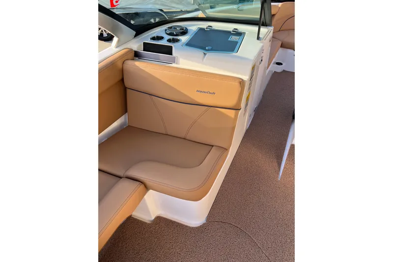 Slide: The Image of 2022 MasterCraft XT25 boat interior with tan leather seating and dashboard controls. - 12