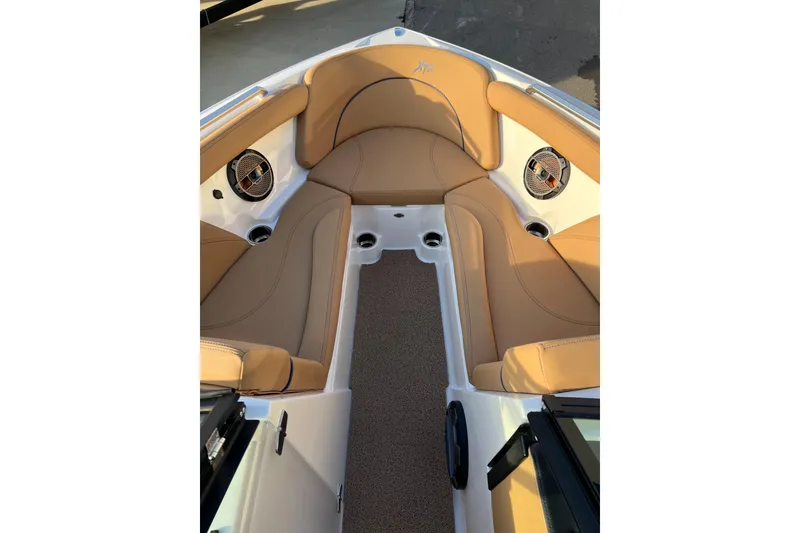 Slide: The Image of 2022 MasterCraft XT25 boat interior with tan seating and built-in speakers. - 15