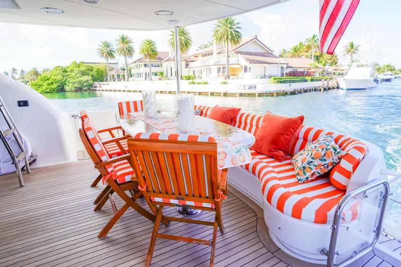 Slide: The Image of Luxurious 2004 Lazzara 80 SL yacht deck with vibrant striped seating and waterfront view. - 15