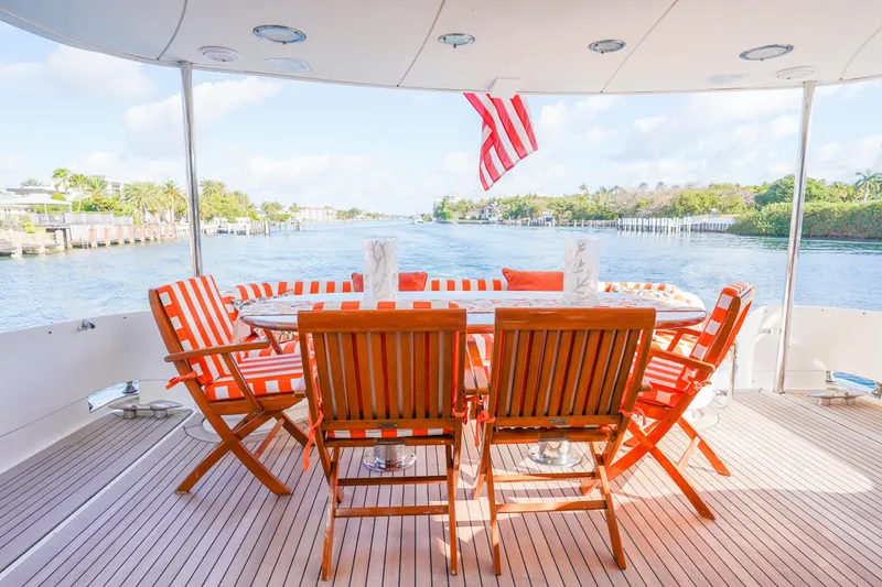 Slide: The Image of Luxury yacht Lazzara 80 SL 2004, deck with striped chairs, table, and scenic water view. - 16