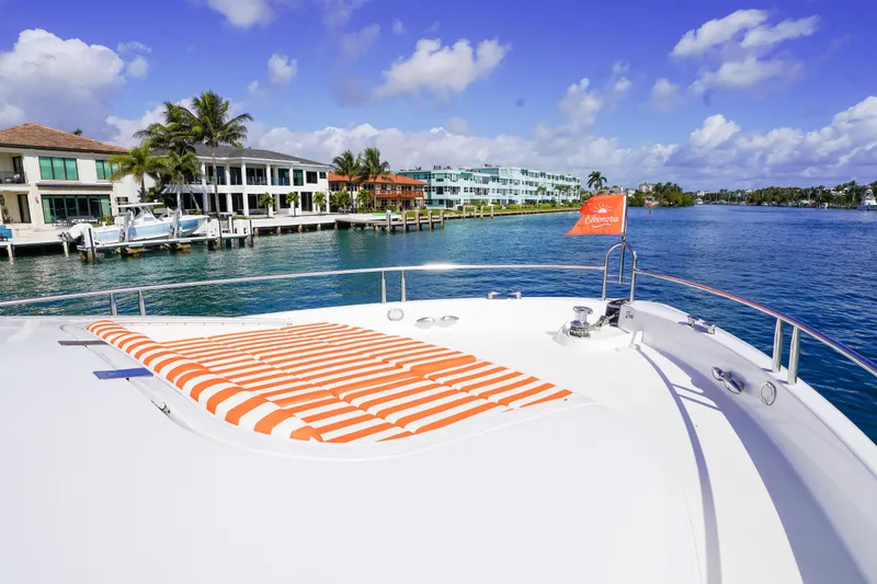 Slide: The Image of 2004 Lazzara 80 SL yacht with striped sunbed, docked near waterfront homes. - 19