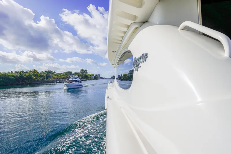 Slide: The Image of 2004 Lazzara 80 SL yacht cruising on a scenic waterway under a blue sky. - 22