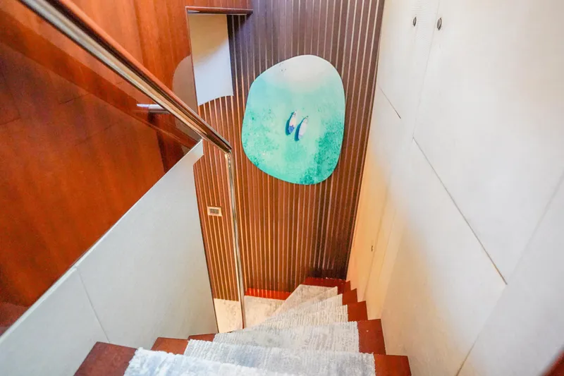 Slide: The Image of Staircase in 2004 Lazzara 80 SL yacht with modern art and wooden paneling. - 40