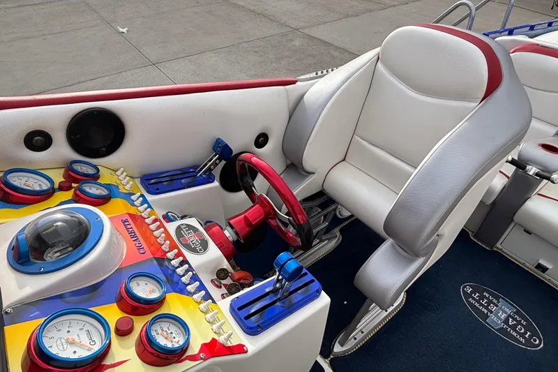Slide: The Image of 2003 Cigarette 38' Top Gun boat cockpit with colorful gauges and plush seating. - 14