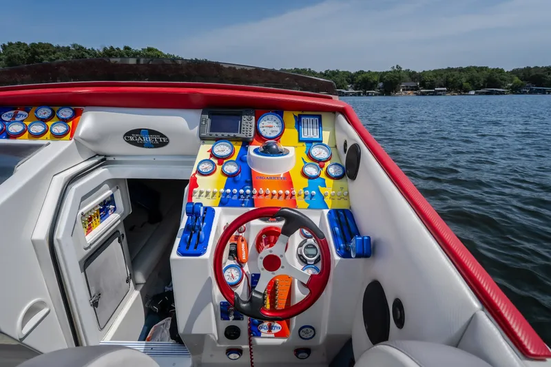 Slide: The Image of Cockpit of a 2003 Cigarette 38' Top Gun boat with colorful gauges and controls. - 20