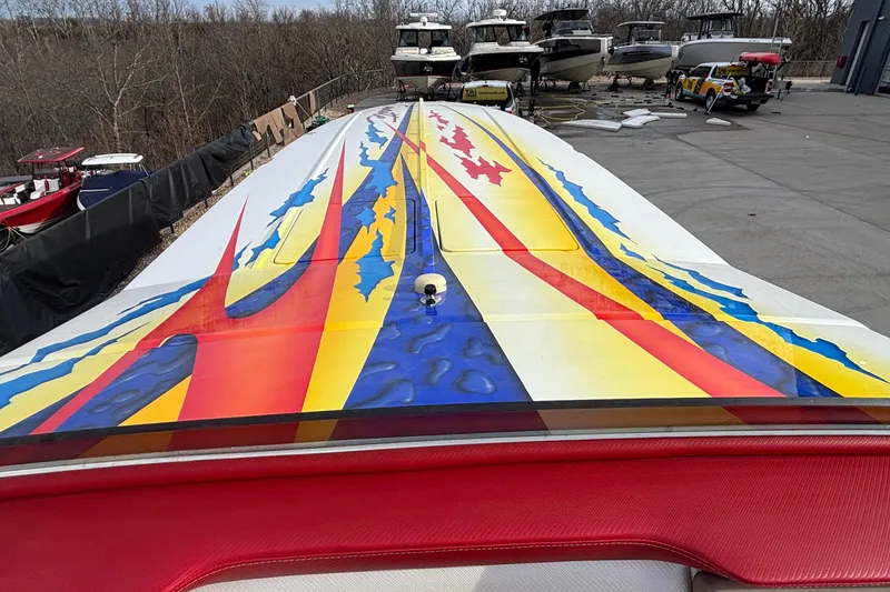 Slide: The Image of 2003 Cigarette 38' Top Gun boat with vibrant, colorful graphics on deck. - 21