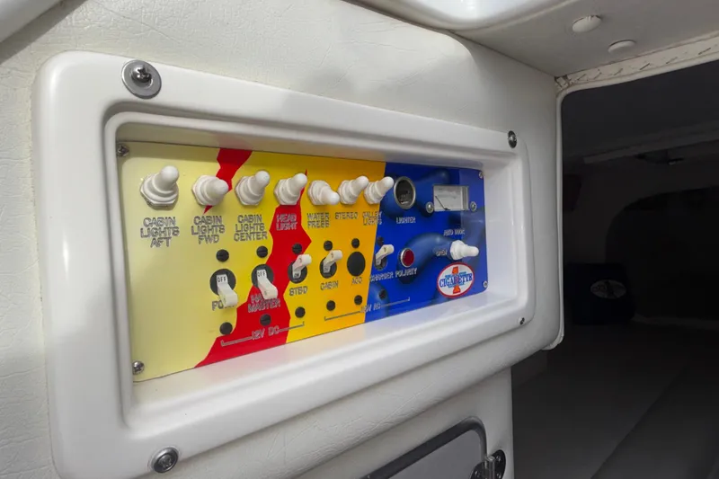 Slide: The Image of Control panel of a 2003 Cigarette 38' Top Gun boat, featuring various switches and labels. - 29