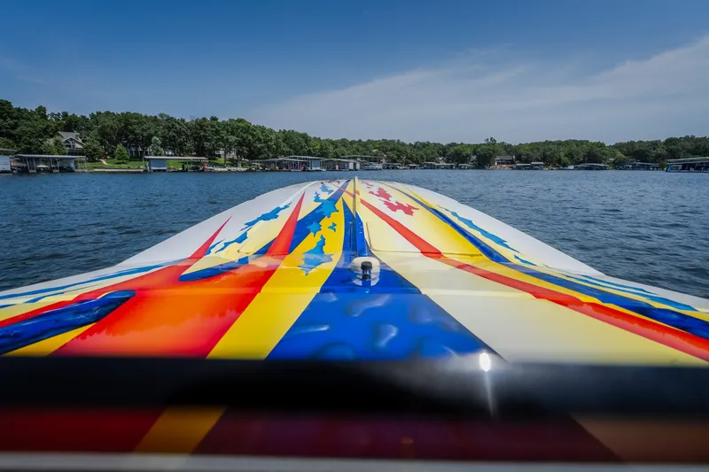 Slide: The Image of 2003 Cigarette 38' Top Gun boat with vibrant, colorful design on water. - 16
