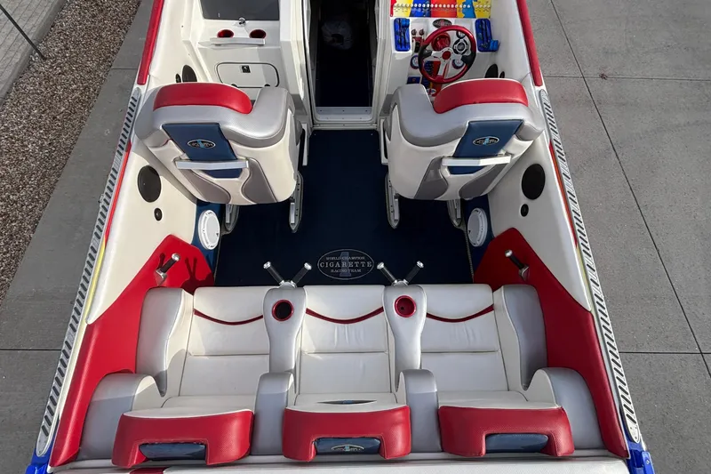 Slide: The Image of 2003 Cigarette 38' Top Gun boat interior with red and white seating, steering wheel, and controls. - 39