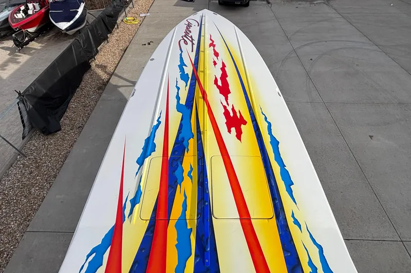 Slide: The Image of 2003 Cigarette 38' Top Gun boat with vibrant red, yellow, and blue graphics. - 40