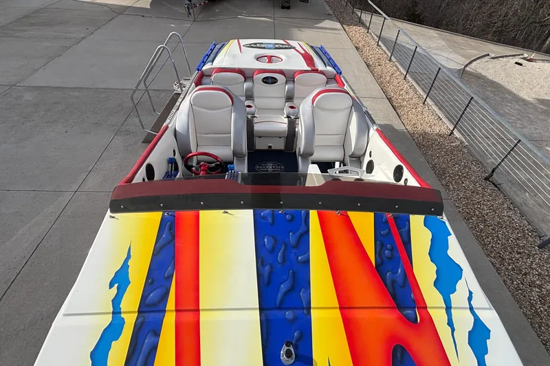 Slide: The Image of 2003 Cigarette 38' Top Gun boat with vibrant, colorful design and sleek seating. - 41