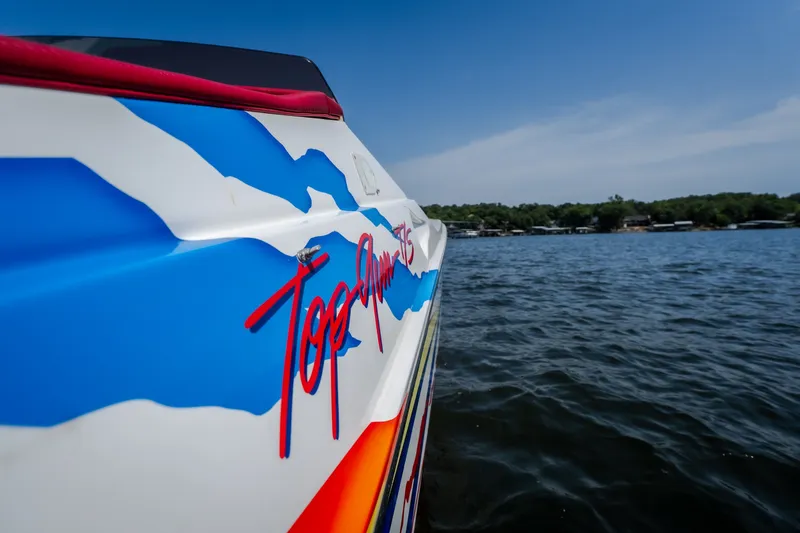 Slide: The Image of 2003 Cigarette 38' Top Gun boat with vibrant graphics on a sunny day. - 21