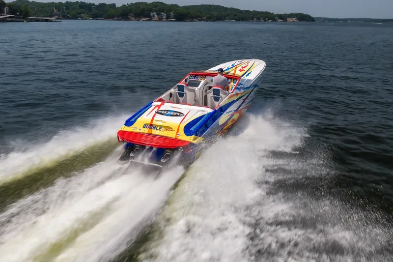 Slide: The Image of 2003 Cigarette 38' Top Gun speedboat racing on open water, vibrant design, powerful wake. - 24