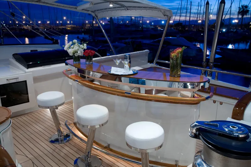 Slide: The Image of Luxurious yacht bar area on 2007 Perini Navi 52M, featuring elegant seating and floral decor. - 14