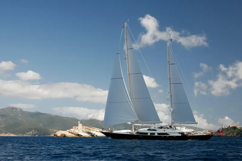 Slide: The Image of Sailing yacht Perini Navi 52M, 2007, cruising near rocky coastline under clear skies. - 9